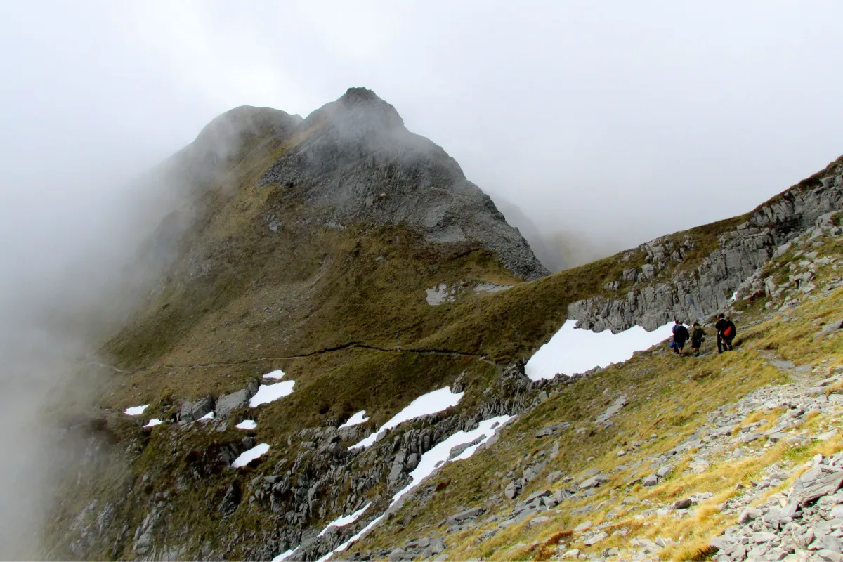 Students hiking through high misty peaks in New Zealand.