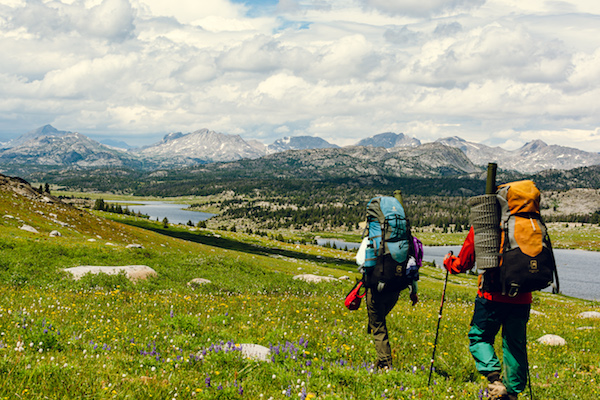 NOLS students hike past alpine lakes and wildflowers in Wyoming's Wind River Range