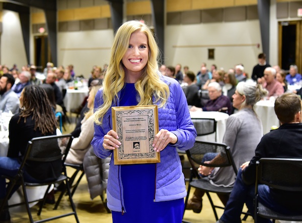 Jessica Wahl smiles while holding 2018 NOLS Stewardship Award