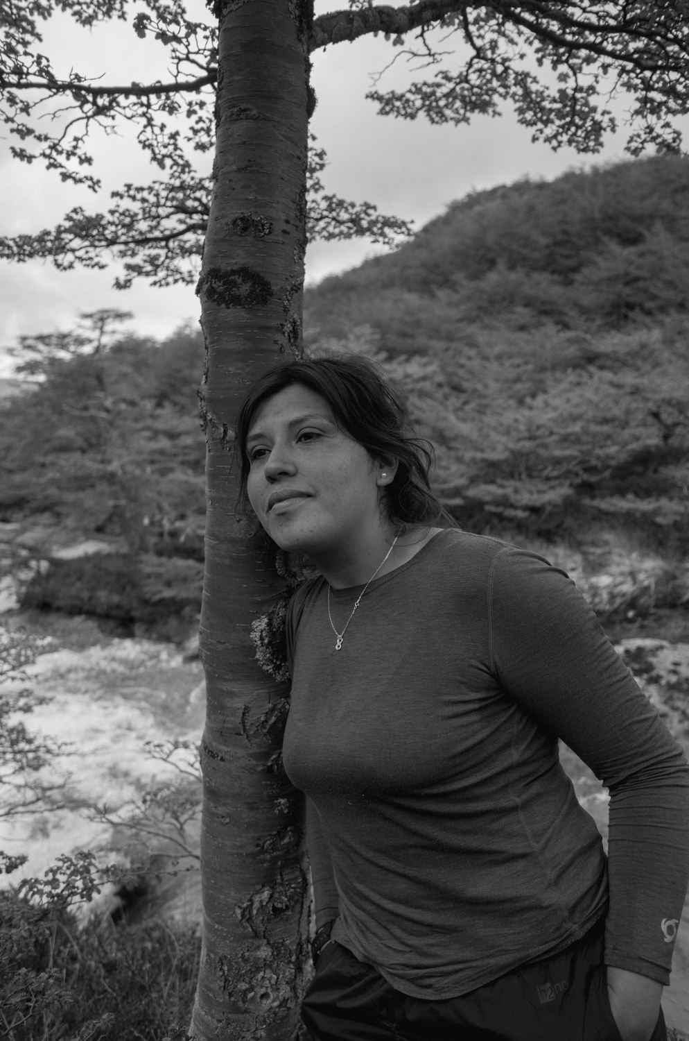Person leaning against a tree
