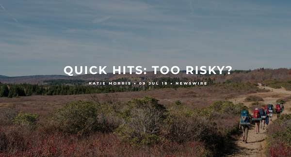 feature photo for "Quick Hits: Too Risky" Newswire article with backpackers hiking along sandy trail