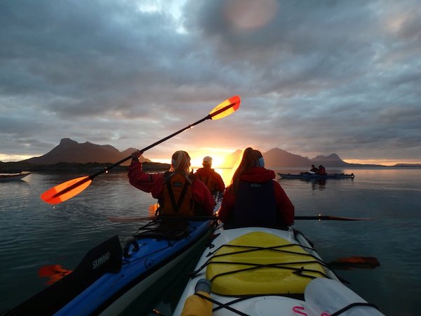 NOLS students paddle sea kayaks in Scandinavia at sunset