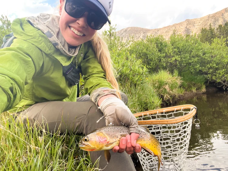 Woman holds fish with net in the other hand.
