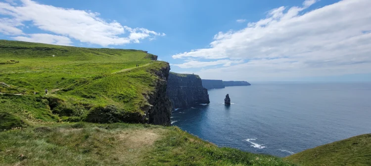 The Irish coast with hikers in the distance and the sea to the right